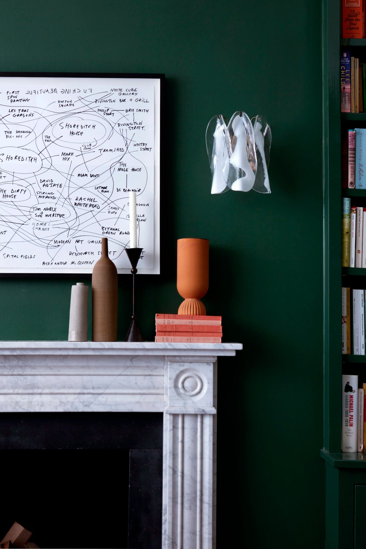 Interior styling by Ida Jacobsson-Wells for Soho Home, featuring a dark green interior with marble fireplace, art and decorative objects